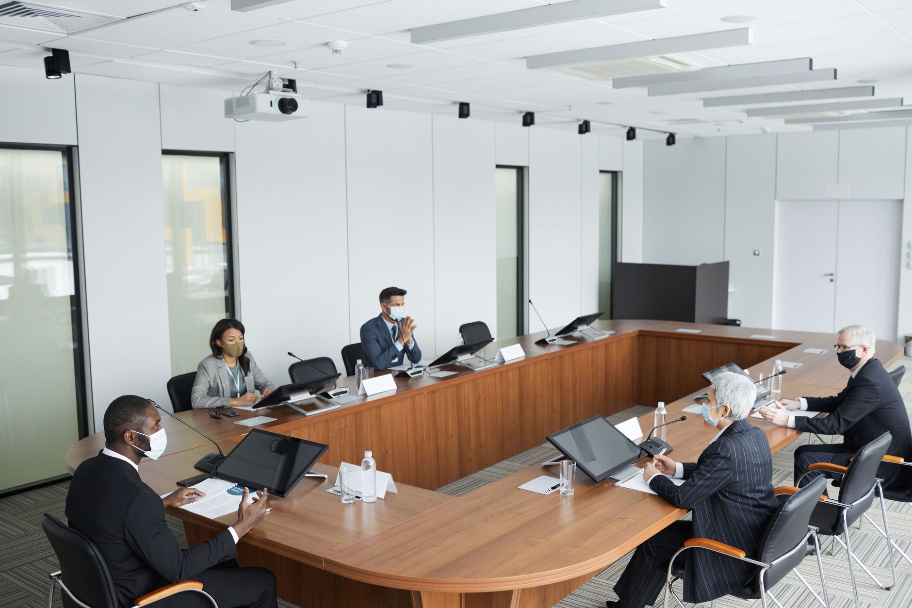 Members of a corporate board in a modern Istanbul boardroom reviewing sustainability reports