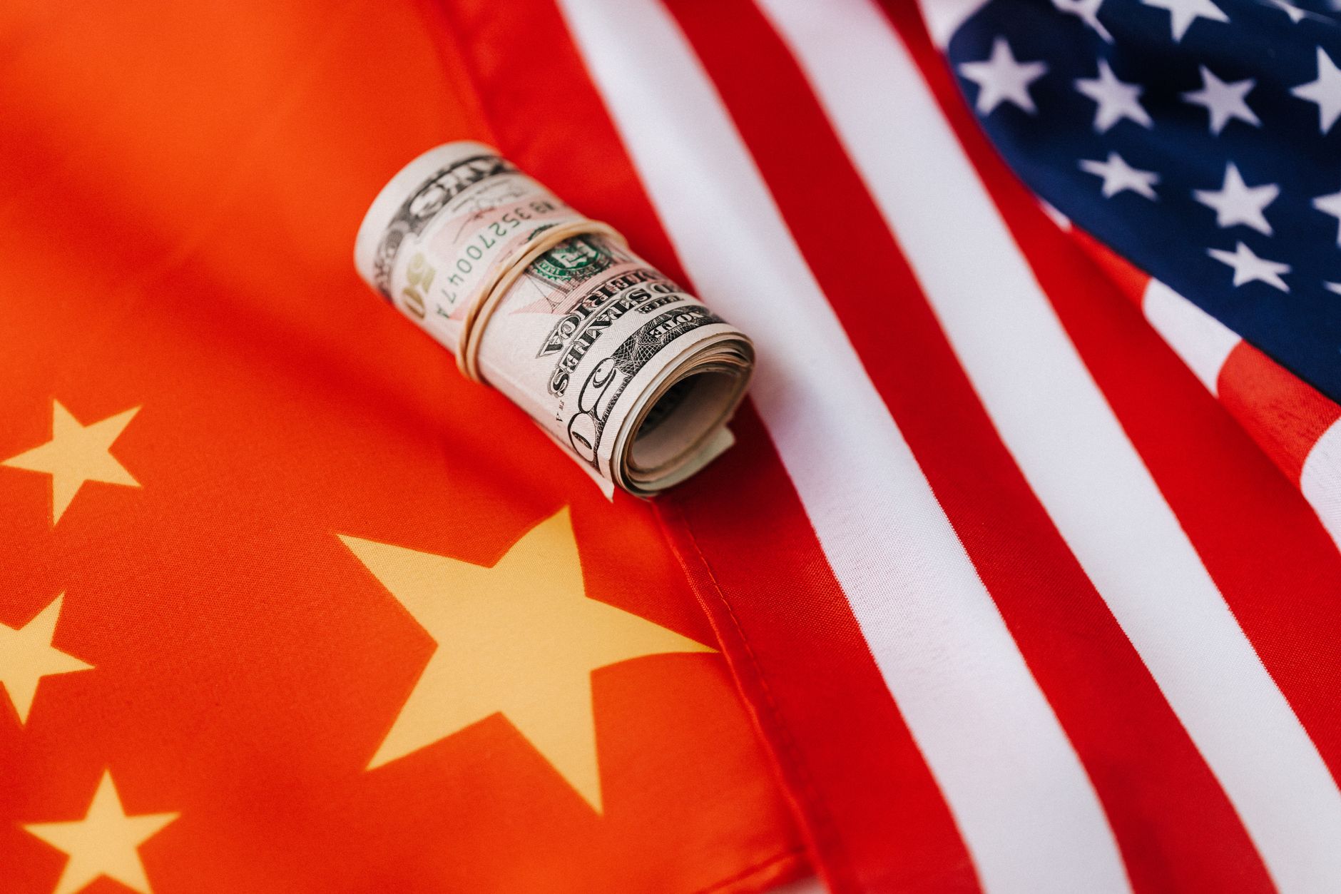 The scales of justice superimposed over a blurred background of international flags, symbolizing comparative criminal law and cross-border legal principles.